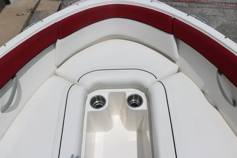Slide: The Image of 2014 Bayliner 185 BR boat interior with red and white seating and cup holders. - 18