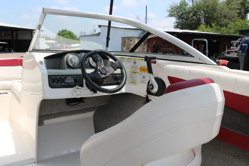 Slide: The Image of Interior view of a 2014 Bayliner 185 BR boat, featuring steering wheel and dashboard. - 22