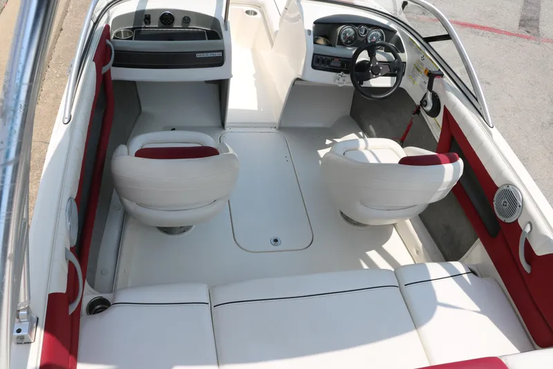 Slide: The Image of 2014 Bayliner 185 BR boat interior with white and red seating, steering wheel, and dashboard. - 31