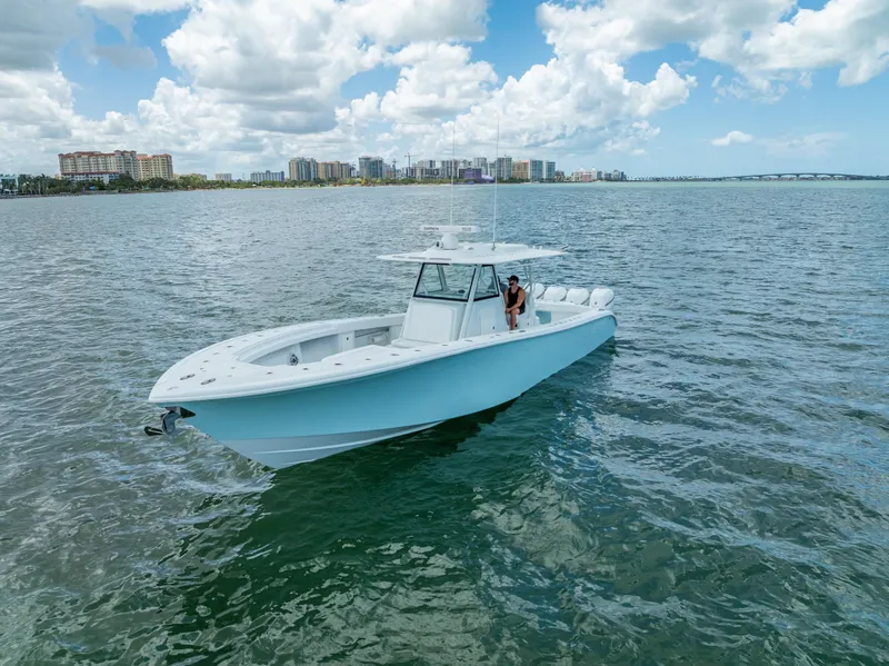 Slide: The Image of 2023 Yellowfin 39 Offshore boat cruising on a sunny day with city skyline in the background. - 10