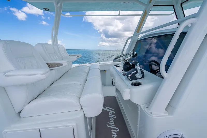 Slide: The Image of 2023 Yellowfin 39 Offshore boat interior with white seating and ocean view. - 31