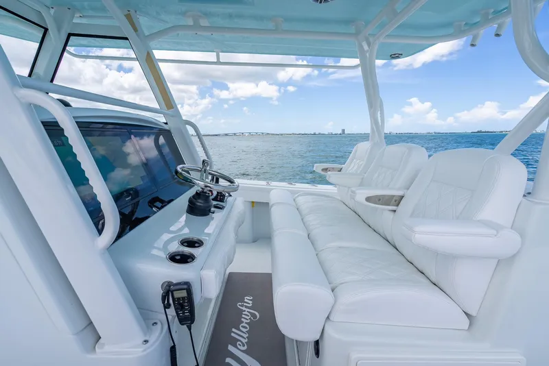 Slide: The Image of 2023 Yellowfin 39 Offshore boat interior with white seating and ocean view. - 32