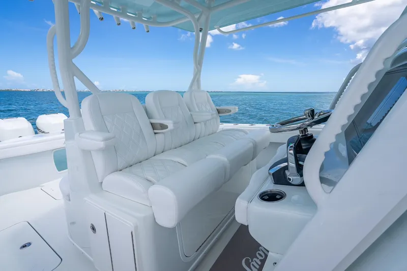 Slide: The Image of 2023 Yellowfin 39 Offshore boat interior with white seating and ocean view. - 35