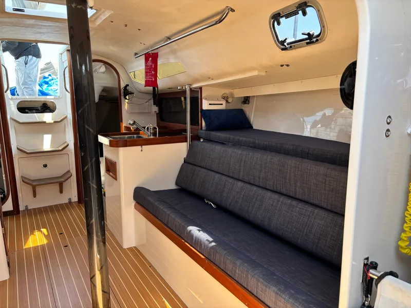 Slide: The Image of Interior of 2018 J Boats J/121 sailboat with seating and compact kitchen area. - 21