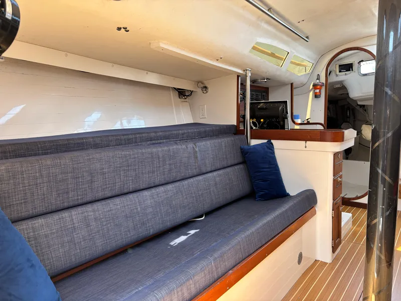 Slide: The Image of Interior of 2018 J Boats J/121 sailboat with blue seating and wooden accents. - 22
