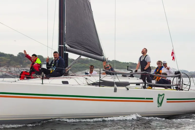 Slide: The Image of 2018 J Boats J/121 sailing with crew on deck, featuring sleek design and black sails. - 5