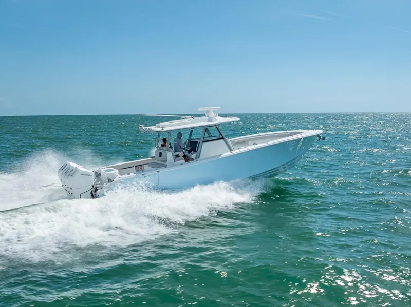 Slide: The Image of 2024 Yellowfin 39 boat cruising on open water under clear blue sky. - 15
