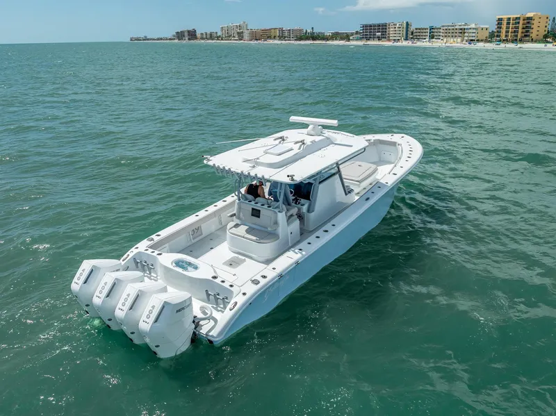 Slide: The Image of 2024 Yellowfin 39 boat cruising on ocean near coastal buildings. - 21