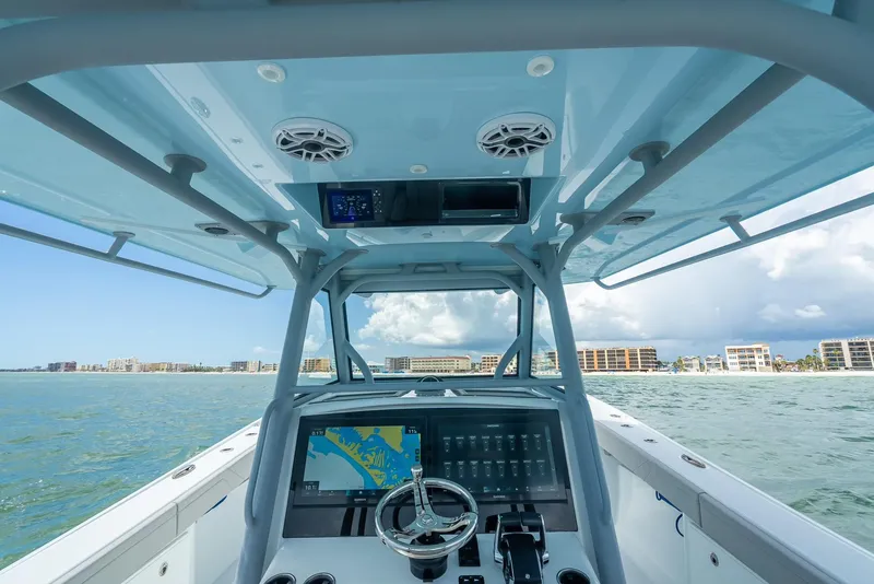 Slide: The Image of 2024 Yellowfin 39 boat helm with navigation system, steering wheel, and ocean view. - 31