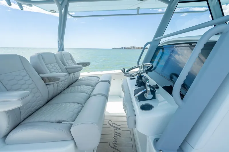 Slide: The Image of 2024 Yellowfin 39 boat interior with luxurious seating and modern helm, overlooking the ocean. - 35