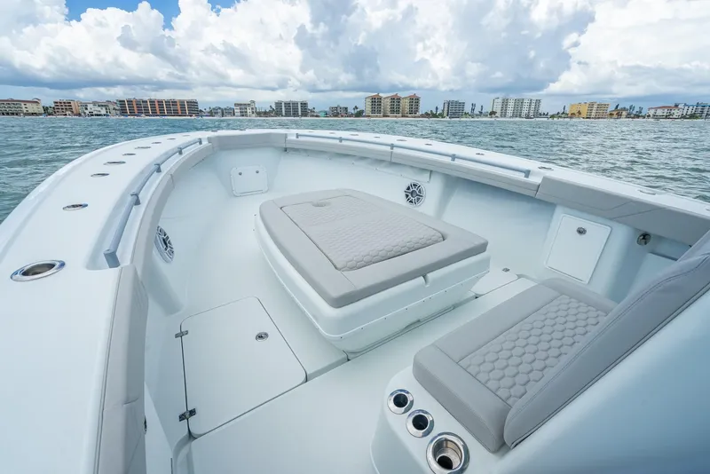 Slide: The Image of 2024 Yellowfin 39 boat interior with cushioned seating, on calm waters. - 43