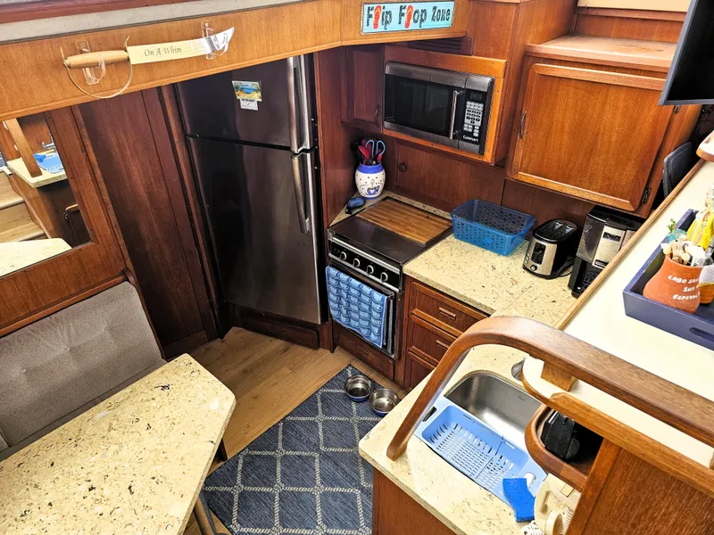 Slide: The Image of 1984 Uniflite 42 Double Cabin kitchen with wood cabinetry, stainless appliances, and cozy dining area. - 11