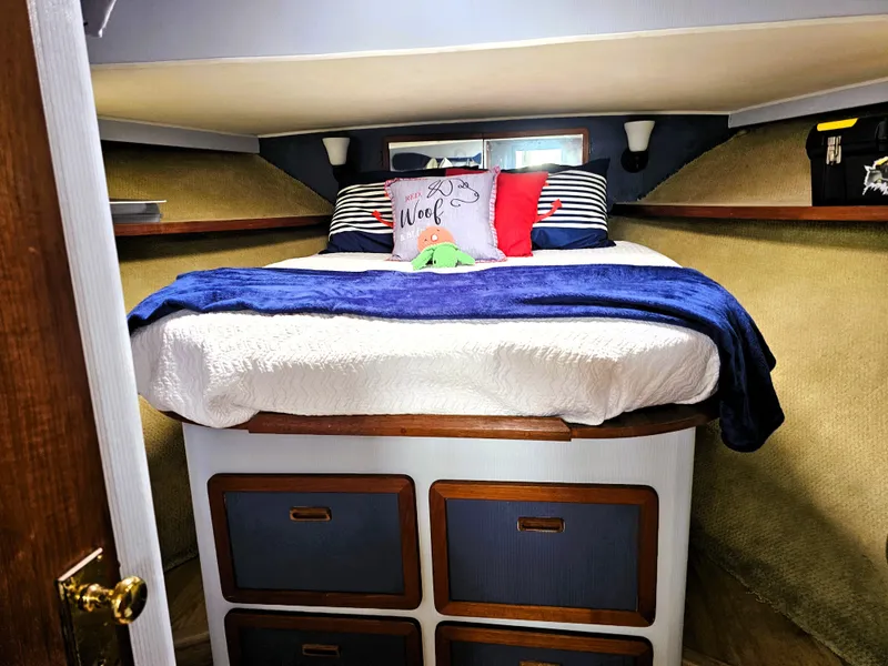 Slide: The Image of Cozy cabin bedroom in 1984 Uniflite 42 Double Cabin with nautical decor and plush bedding. - 14