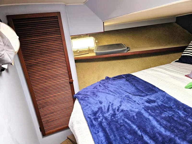 Slide: The Image of 1984 Uniflite 42 Double Cabin interior with bed, wooden closet, and shelf. - 16