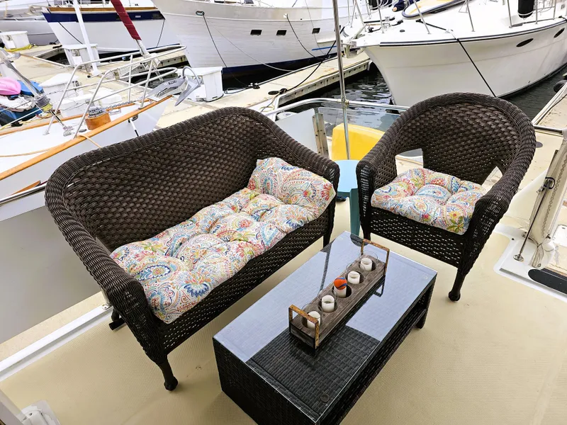 Slide: The Image of Wicker seating on 1984 Uniflite 42 Double Cabin yacht deck, with colorful cushions and table. - 2