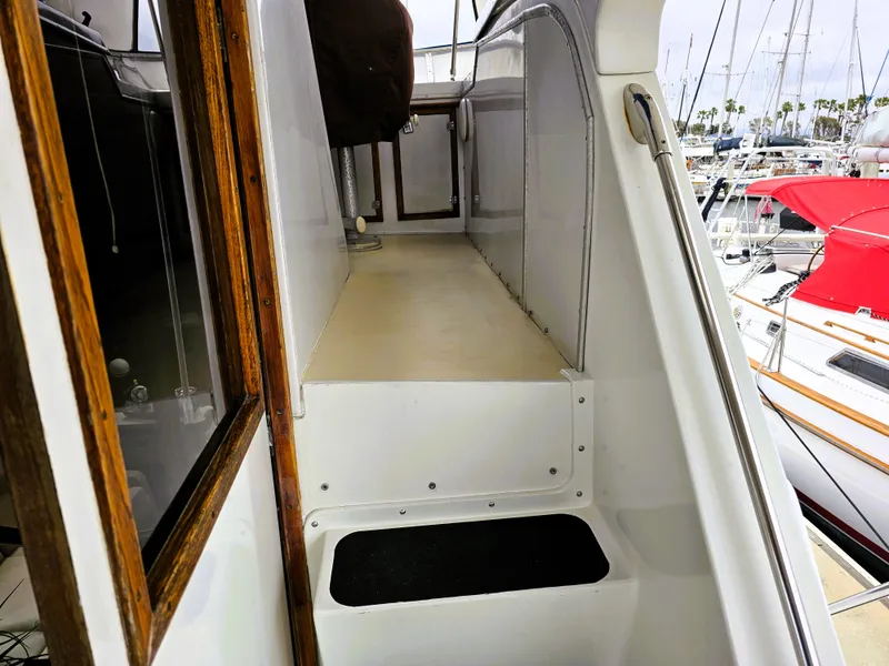 Slide: The Image of 1984 Uniflite 42 Double Cabin yacht deck with wooden accents and marina view. - 28