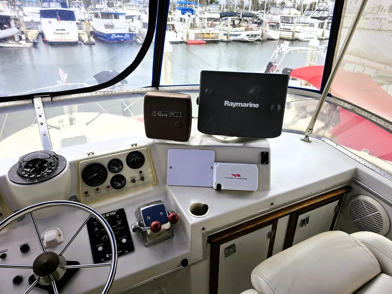 Slide: The Image of 1984 Uniflite 42 Double Cabin helm with navigation equipment, overlooking marina. - 33