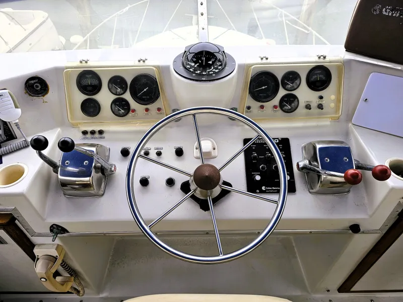 Slide: The Image of 1984 Uniflite 42 Double Cabin helm with steering wheel, gauges, and controls. - 34