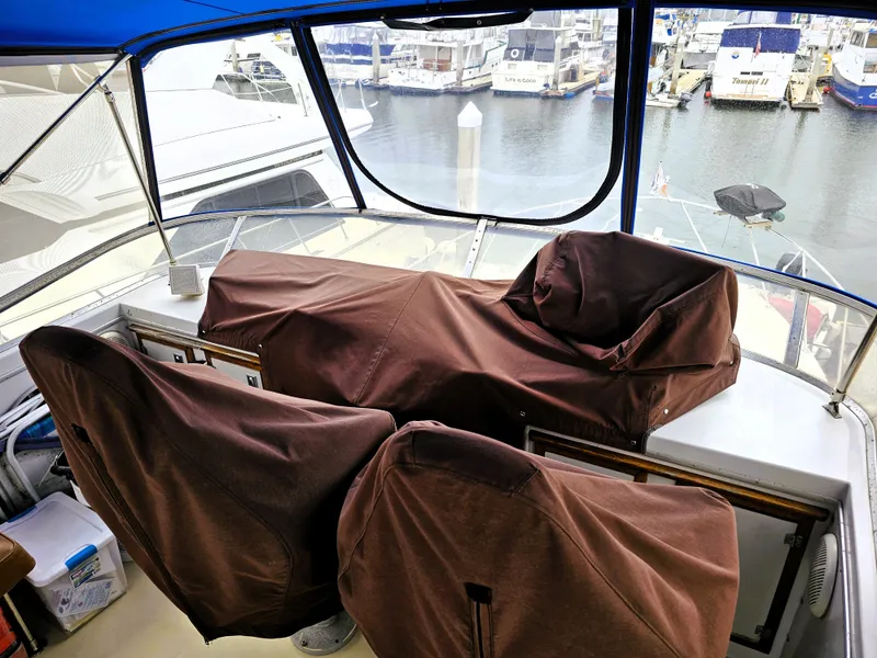 Slide: The Image of 1984 Uniflite 42 Double Cabin helm with covered seats, overlooking marina. - 35