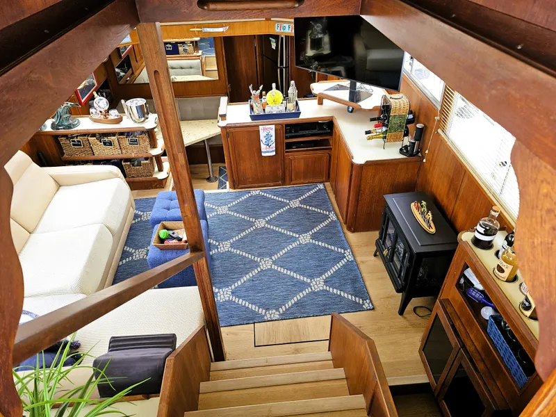 Slide: The Image of 1984 Uniflite 42 Double Cabin interior with cozy seating, blue rug, and wooden decor. - 4