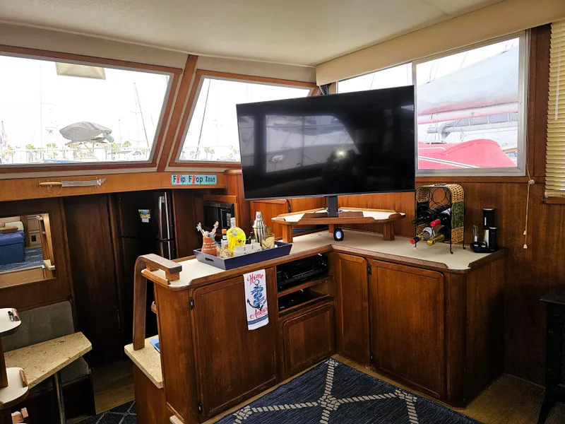 Slide: The Image of 1984 Uniflite 42 Double Cabin interior with TV, wooden cabinetry, and nautical decor. - 7