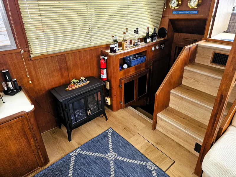 Slide: The Image of 1984 Uniflite 42 Double Cabin interior with wooden stairs, bar area, and nautical decor. - 9
