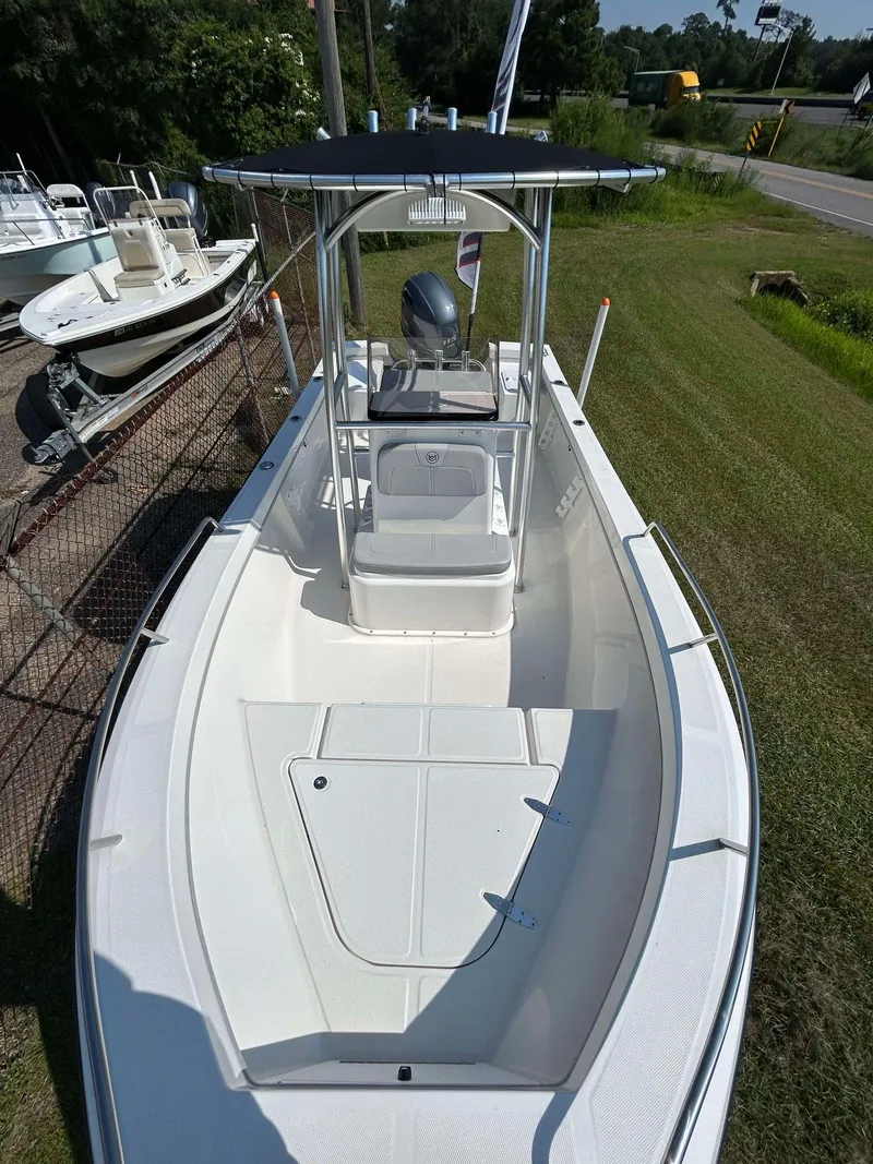 Slide: The Image of 2024 May-Craft 1900CC boat with center console, parked on grass near a fence. - 23