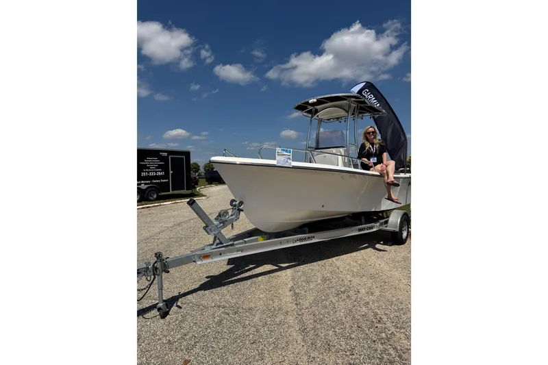 Slide: The Image of 2024 May-Craft 1900CC boat on trailer with person sitting, under clear blue sky. - 26