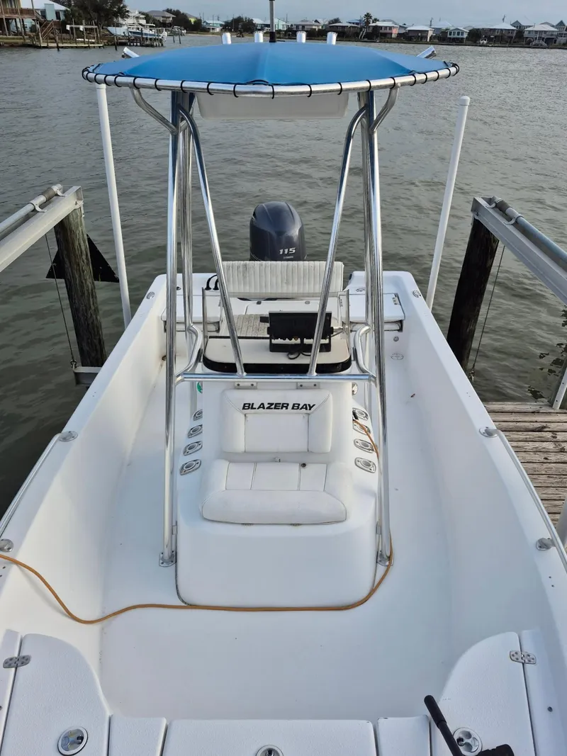 Slide: The Image of 2017 Blazer Bay 1900 boat docked, featuring a blue canopy and outboard motor. - 3