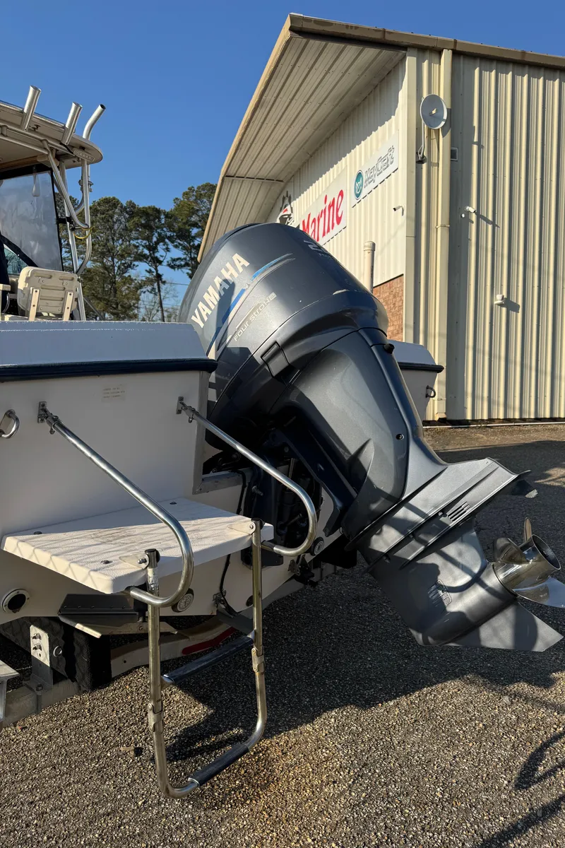 Slide: The Image of 1993 Grady-White Seafarer 22 with Yamaha outboard motor, parked near a marine service building. - 12