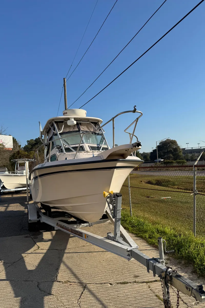 Slide: The Image of 1993 Grady-White Seafarer 22 boat on trailer, parked outdoors under clear blue sky. - 13