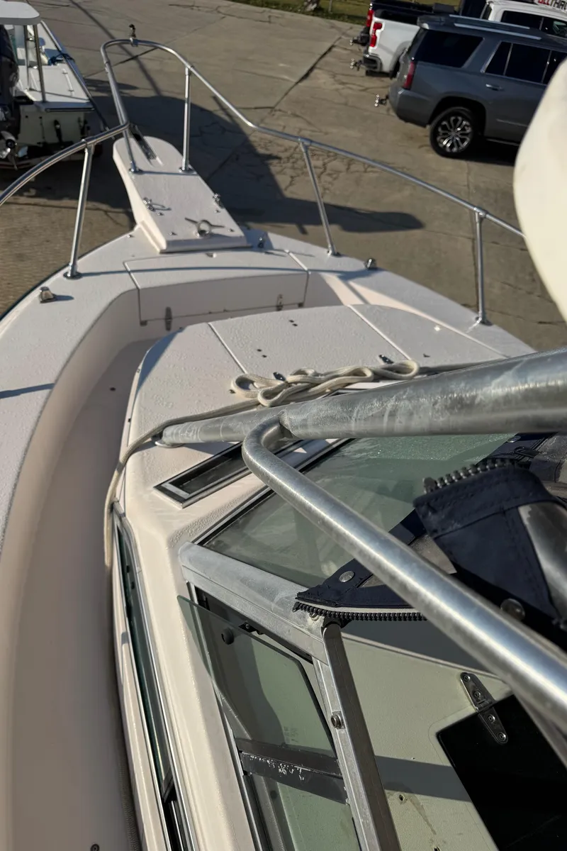 Slide: The Image of 1993 Grady-White Seafarer 22 boat deck with railing and parked vehicles in background. - 9