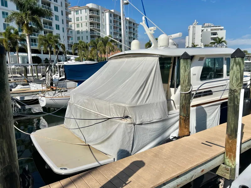 Slide: The Image of 2017 Sabre 48 Salon Express yacht docked at marina with cover, surrounded by buildings. - 4