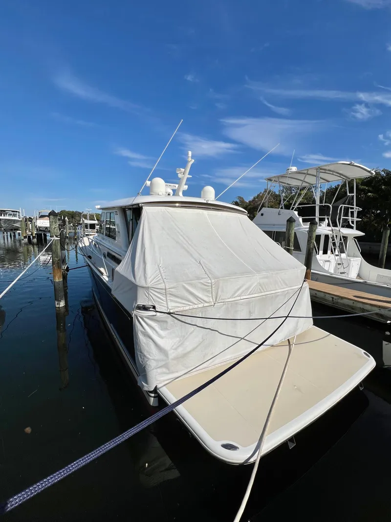 Slide: The Image of 2017 Sabre 48 Salon Express yacht docked with cover, under clear blue sky. - 8