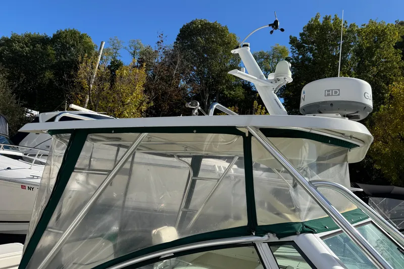 Slide: The Image of 1998 Pursuit 2800 Walkaround boat with radar, docked under clear blue sky. - 12