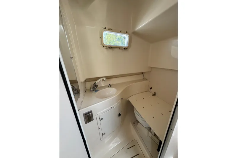 Slide: The Image of 1998 Pursuit 2800 Walkaround boat interior bathroom with sink and window. - 18