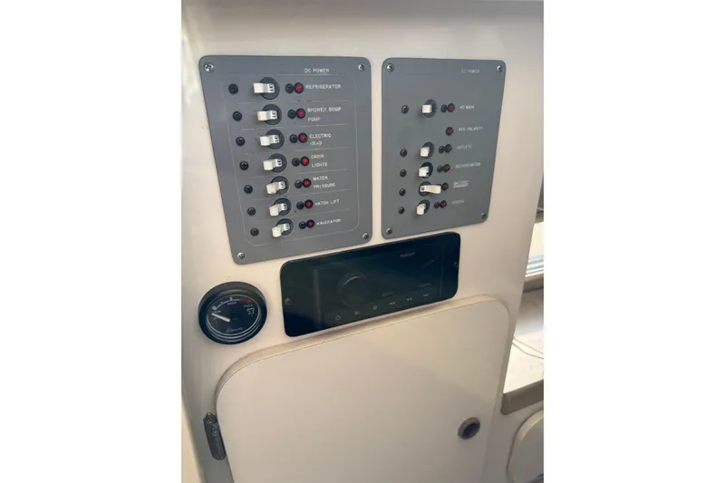 Slide: The Image of Control panel of a 1998 Pursuit 2800 Walkaround boat, featuring switches and gauges. - 19