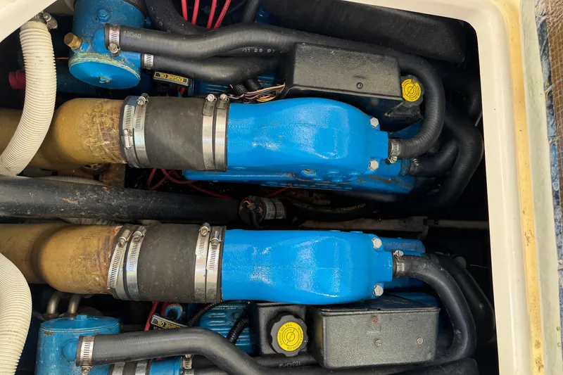 Slide: The Image of Engine compartment of a 1998 Pursuit 2800 Walkaround boat, featuring blue engine components. - 20