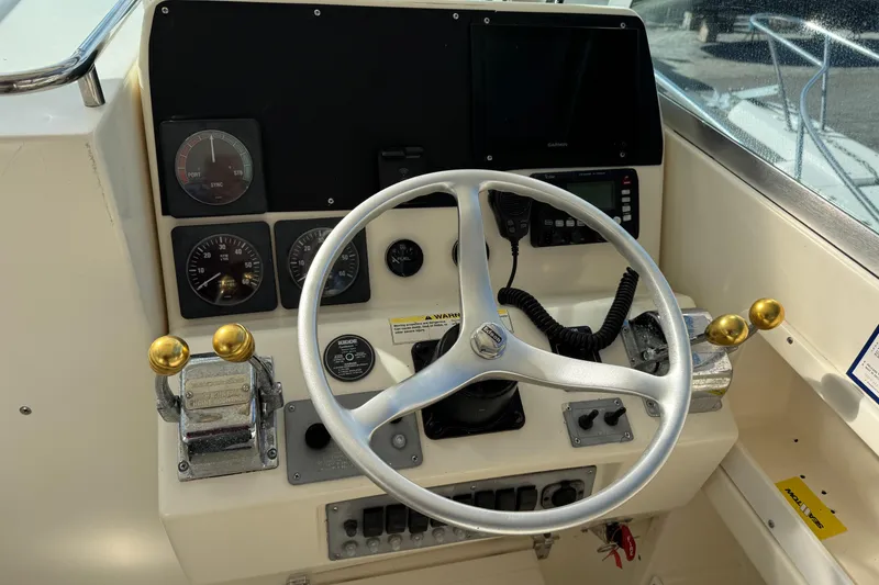 Slide: The Image of Control panel of a 1998 Pursuit 2800 Walkaround boat with steering wheel and gauges. - 5