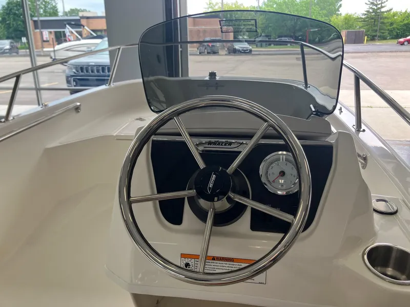 Slide: The Image of 2025 Boston Whaler 130 Super Sport boat dashboard with steering wheel and gauge. - 6