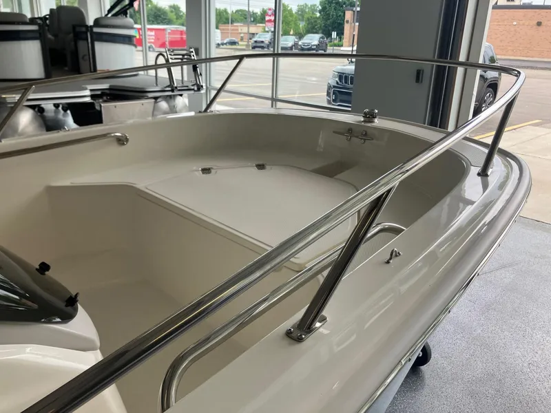 Slide: The Image of 2025 Boston Whaler 130 Super Sport boat interior with stainless steel railings in showroom. - 7