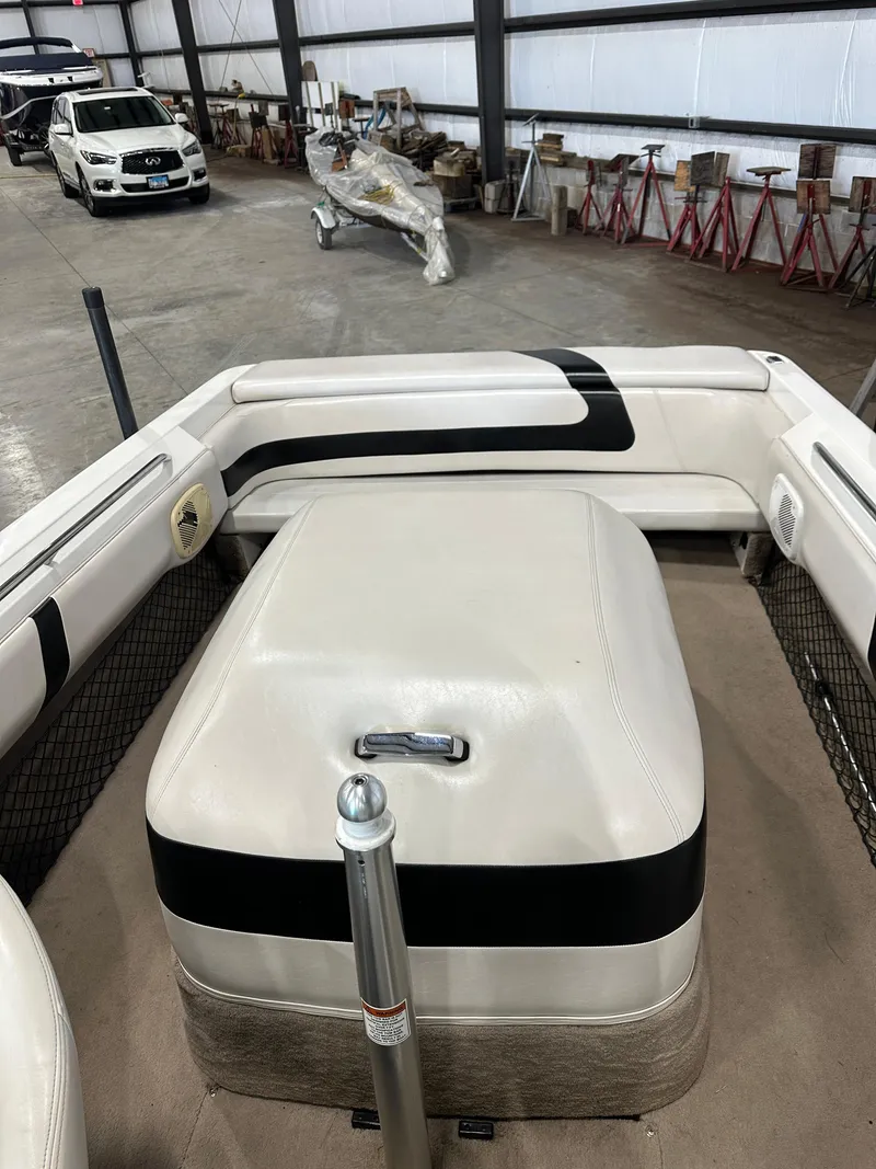 Slide: The Image of 1998 MasterCraft Pro Star 190 boat interior with white and black seating in a storage facility. - 7