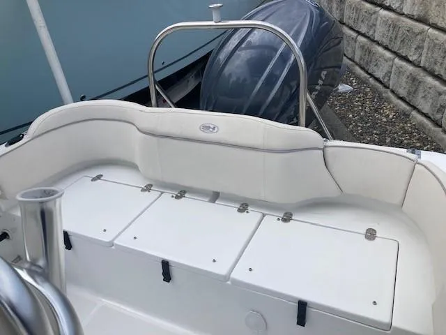 Slide: The Image of 2024 Sea Hunt Ultra 229 boat interior with white seating and storage compartments. - 10