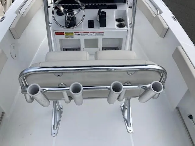 Slide: The Image of 2024 Sea Hunt Ultra 229 boat interior with steering console and rod holders. - 12