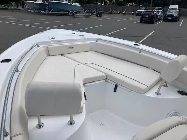 Slide: The Image of 2024 Sea Hunt Ultra 229 boat with spacious seating in a parking lot. - 7