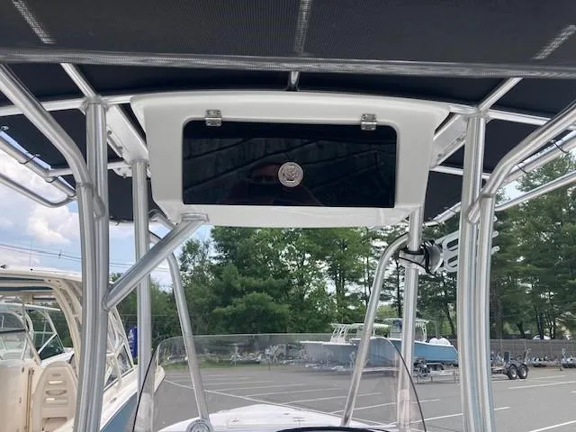 Slide: The Image of 2024 Sea Hunt Ultra 229 boat with T-top and console, parked outdoors. - 8