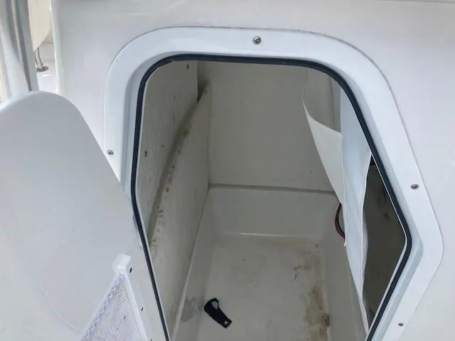 Slide: The Image of 2024 Sea Hunt Ultra 229 boat storage compartment with open door. - 9