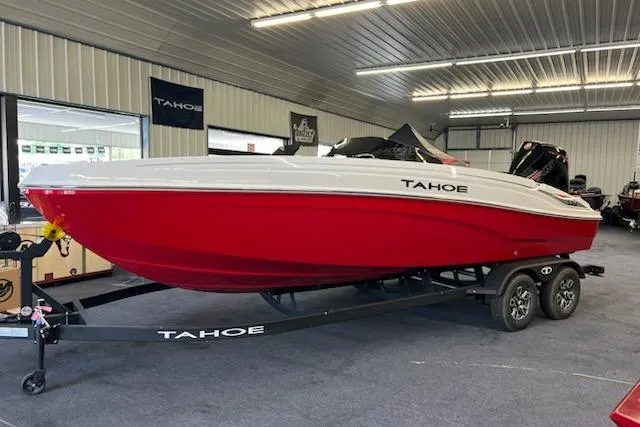 Slide: The Image of 2025 Tahoe T21 boat in showroom, red and white design, on trailer. - 2