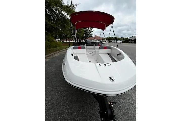 Slide: The Image of 2025 Tahoe T16 boat with red canopy, parked on a road, showcasing sleek design. - 10