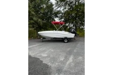 Slide: The Image of 2025 Tahoe T16 boat with red canopy on trailer, parked outdoors. - 3